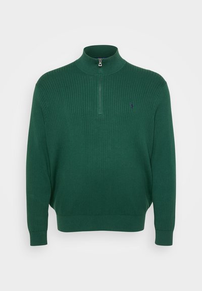 Suéter de malha canelada verde-escuro com gola alta e meio fecho, apresentando um pequeno logótipo bordado no peito.
