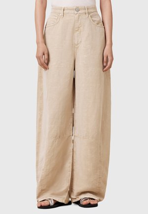 Beige wijdvallende broek van lichtgewicht stof, met een hoge taille, voorzakken en zichtbare stikseldetails langs de naden.
