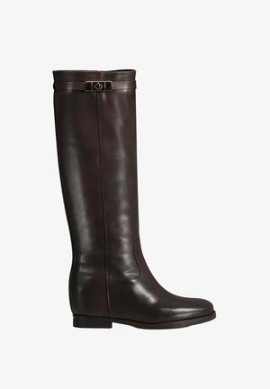 Knielange glanzend donkerbruine leren laarzen met een gladde textuur, uitgerust met een gouden gespaccent bovenaan en een lage blokhak.