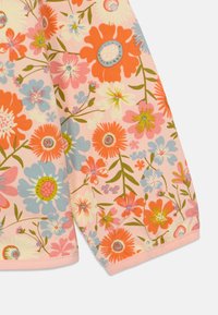 Tecido floral com flores brilhantes em laranja, rosa e azul sobre um fundo rosa suave. Textura lisa com borda rematada.