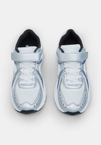 Chaussures de sport blanches avec upper en maille, accents argentés, fermetures à lacets et à Velcro. Bout arrondi et intérieur noir rembourré.