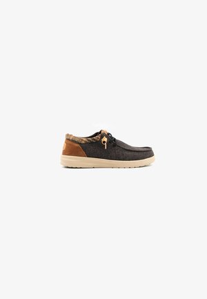 Zapato de tela gris oscuro con detalles de cuero marrón, puntera redonda y forro con estampado. Presenta cordones negros y suela de goma.