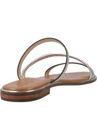 Sandalias planas marrones con dos correas metálicas semitransparentes. La suela interior presenta un diseño texturizado. Suela delgada y discreta.