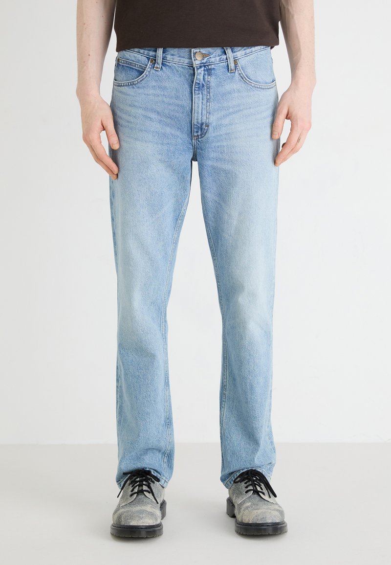 Light blue denim jeans with a straight fit, classic five-pocket design, and a zip fly. Soft texture with slight fading on the legs.