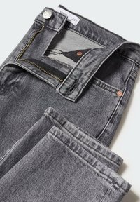 Jeans de mezclilla gris con cremallera y cierre de botón. Presentan una textura suave, corte recto y acentos de doble costura.