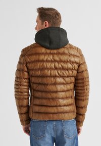 Braune Pufferjacke mit horizontalen Steppnähten, ausgestattet mit einer dunkelgrauen Kapuze und einem gerippten Kragen, aus glänzendem Leder gefertigt.
