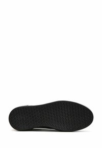 Semelle de chaussure en caoutchouc noir avec un motif hexagonal. Présente un bord lisse et une légère courbure. Conception globale durable et flexible.