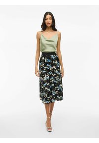 Hemdchen aus leicht grünem Satin, kombiniert mit einem plissierten schwarzen Rock mit einem blau-weißen Blumenmuster. Abgerundet mit einem schwarzen Taillenbund.