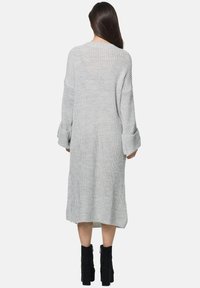 Langes, lockeres, graues Strickkleid mit herabgesetzten Schultern und gerippten Manschetten, in mittlerer Wadenlänge und mit strukturiertem Stoff.