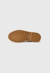 Rubber outsole with a textured brown surface, featuring a zigzag pattern and reinforced toe area for enhanced traction and durability.
