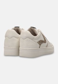 White sneakers with a textured leather upper, featuring a brown spotted accent pattern, padded collar, and a thick white sole.