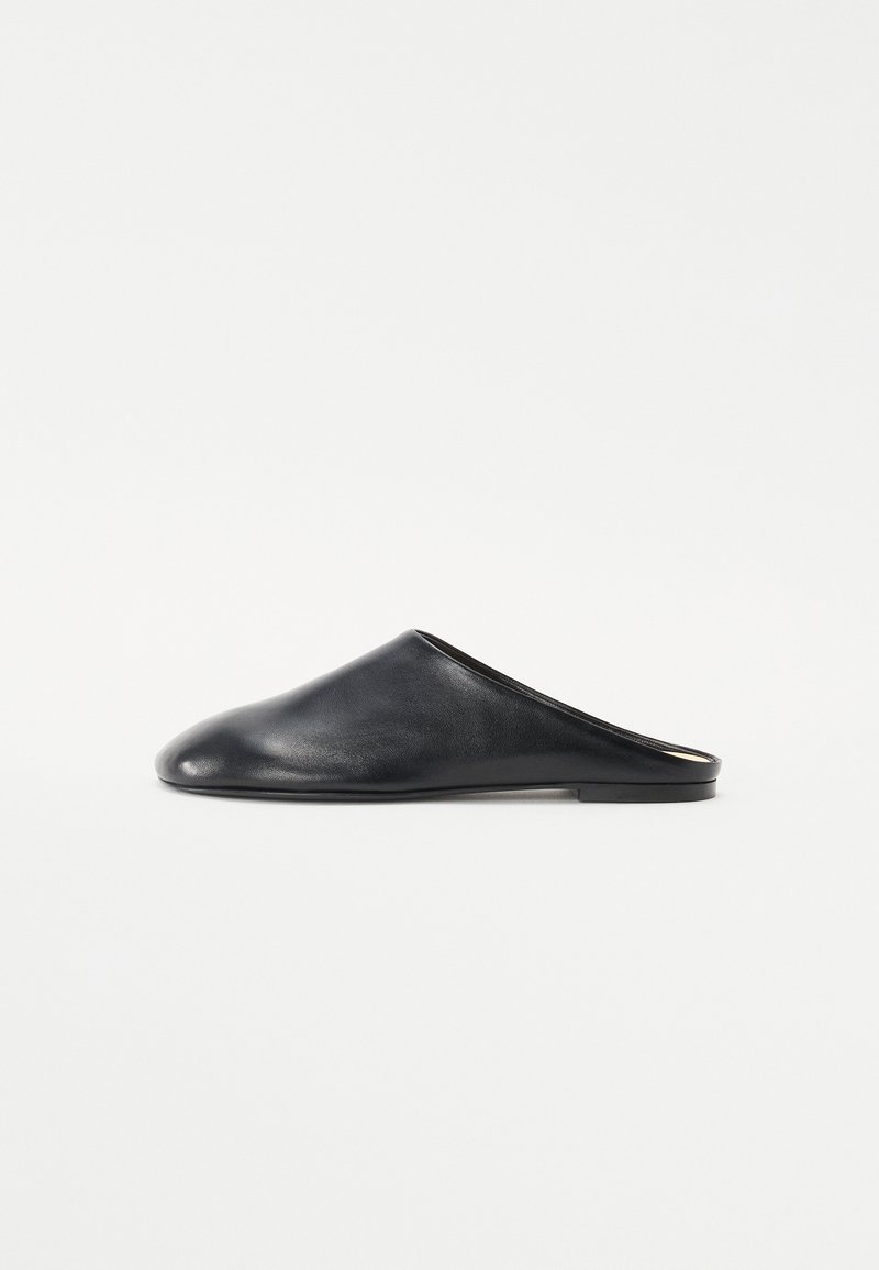 Melnas ādas slip-on mules ar noapaļotu purngalu un zemu platu zoli. Gluda tekstūra ar minimālistisku dizainu un bez redzama aprīkojuma.