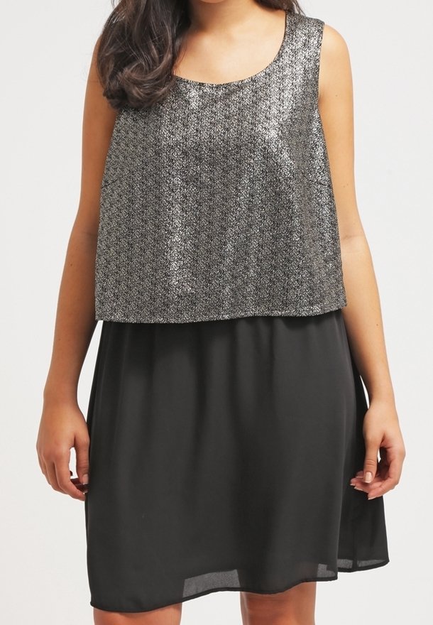 Šaty bez rukávů s lesklým kovovým stříbrným vrškem a splývavou černou sukní. Hladký textilní materiál s uvolněným střihem.