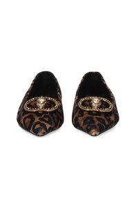 Zapatos planos de punta afilada en tela de estampado animal. Presentan un acento decorativo en tono dorado con gemas transparentes. Textura suave, colores marrón y negro.