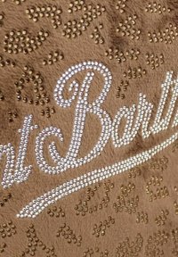 Tessuto marrone con texture, adornato da strass bianchi e dorati che formano una scrittura decorativa e motivi astratti.