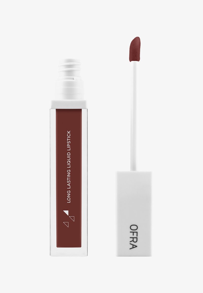 Rouge à lèvres liquide dans un tube transparent avec un capuchon blanc. La teinte est un bourgogne profond. L'applicateur a une pointe douce et arrondie pour une application précise.