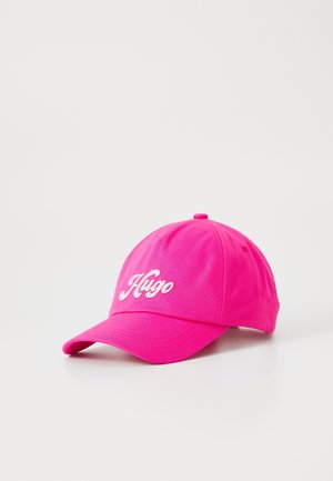 Lyserød baseballkasket med buet skygge og hvidt broderet "Hugo"-logo på fronten, sat mod en ensartet lys baggrund.