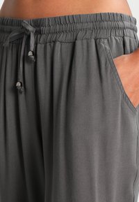 Luftige, locker sitzende, dunkelgraue Hose mit elastischem Bund und Kordelzug, seitlichen Taschen und einer glatten, leichten Stoffstruktur.