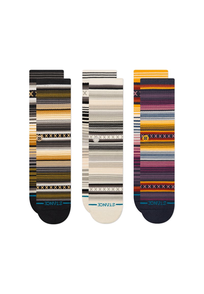 Tres pares de calcetines estampados con rayas en varios colores, incluyendo amarillo, gris, negro y púrpura. Cada calcetín tiene un diseño y textura únicos.
