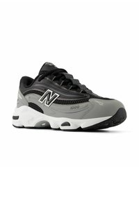 Sneaker New Balance 1000 grigia e nera con pannelli in rete, suola imbottita bianca e lacci neri inclinati per mostrare il lato esterno.