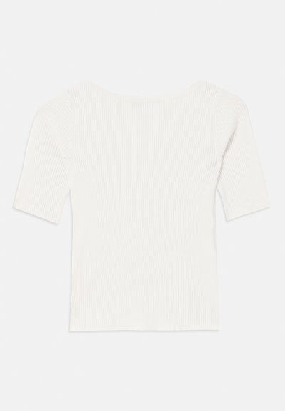 Top bianco a righe con maniche corte e scollo ampio. La texture presenta strisce verticali, enfatizzando una vestibilità aderente e un design semplice.