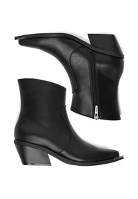 Botines de cuero negro con tacón grueso, con cremallera lateral y textura suave. El diseño es elegante con puntera redondeada.