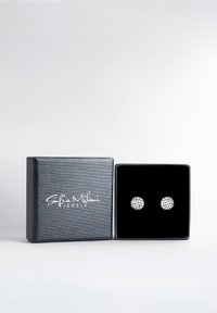 Orecchini a bottoniera in argento con intricati motivi geometrici, esposti in una scatola foderata in velluto nero con un esterno grigio scuro e texture.