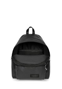 Mochila de tela negra con un diseño redondeado, compartimento principal con cremallera, bolsillo frontal y parche con logo. Cuenta con un asa superior y correas ajustables.