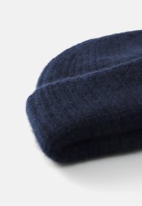 Marineblå strikket lue med en myk tekstur, preget av ribbestrikket design og en brettet kant for ekstra varme. Ingen synlige merker eller detaljer.