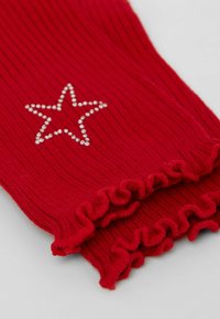 Guanti senza dita a coste rosse con bordo arricciato e un design di stelle in strass sulla parte anteriore. Tessuto morbido, materiale elastico.