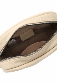 Borsetta in pelle beige con finitura texture. All'interno presenta una fodera liscia e una piccola tasca a fessura. Chiusura con zip e hardware argentato.