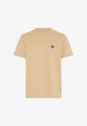 Beige pamut póló rövid ujjakkal, kerek nyakkal, és egy kis fekete hatszögletű logóval a bal mellkasi részen. Simágyi tulajdonság.