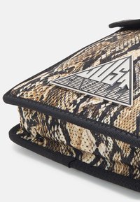 Borsa con motivo di pelle di serpente e bordi neri, caratterizzata da un logo triangolare argentato sulla parte anteriore. Superficie testurizzata con chiusura a zip.