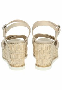 Beige kile-sandaler med en struktureret vævet hæl, ankelrem med en sølvspænde og en glat mat fodseng. Elegant og struktureret design.