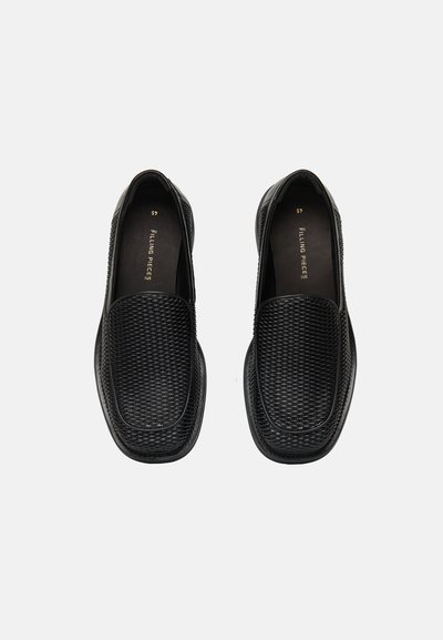 Ζευγάρι μαύρα πλεκτά δερμάτινα loafers χωρίς κορδόνια με στρογγυλεμένα τετράγωνα μύτες και σήμανση "Filling Pieces" στο εσωτερικό.