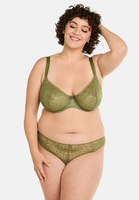 Soutien-gorge en dentelle verte et string assorti avec des motifs floraux, des bretelles réglables et une texture douce. Les deux pièces présentent un design délicat et transparent.