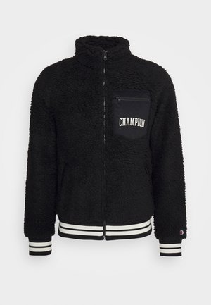 Schwarze Fleecejacke mit hohem Kragen, Frontreißverschluss und gestepptem Logo-Taschen. Mit gestreiftem Rippstrick an den Bündchen und dem Saum. Weiches, strukturiertes Material.