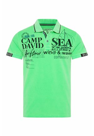 Groene katoenen polo met zwarte grafische prints, horizontale strepen op de kraag en een merkaanraking op de mouw.