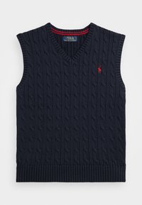Suéter sin mangas de punto azul marino con escote en V, con un patrón de punto de cable y dobladillo acanalado. Acento rojo en el escote y en el logo.
