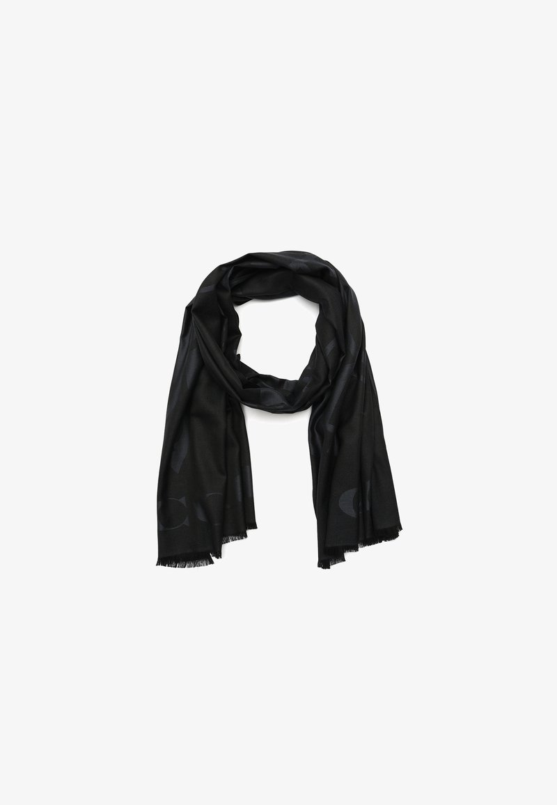 Écharpe légère noire avec motif subtil et bords frangés, pliée en boucle lâche sur fond blanc.