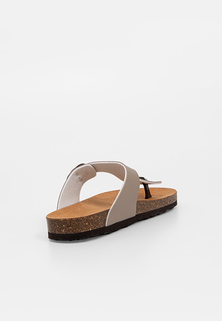Tongs en liège avec semelle en caoutchouc, dotées d'un dessus en synthétique beige, d'un design à entre-doigt et d'une semelle noire contrastante. Texture lisse et coutures minimales.