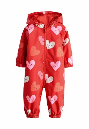 Red waterproof overall with a hood, featuring a pattern of varied pink and white smiling hearts. Elastic cuffs for a secure fit.