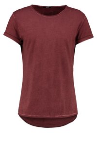 Bordowa koszulka z okrągłym dekoltem, krótkimi, podwiniętymi rękawami i nieco dłuższym tyłem. Miękka tekstura z swobodnym krojem.