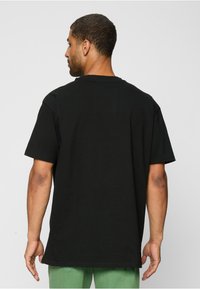 Mister Tee AALIYAH - Nyomott mintás póló - black