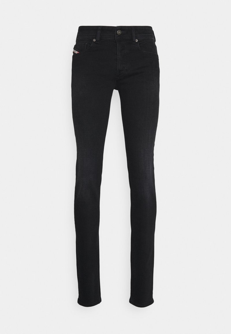Černé skinny džíny vyrobené z denimu, s klasickým pětikapsovým designem, zipem a kontrastním prošíváním. Hladká textura a štíhlý střih.