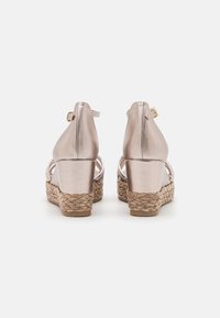 Metallic rosegold Wedge-Sandaletten mit gewebten Jute-Akzenten, offener Rückseite, verstellbarem Knöchelriemen und glatter, glänzender Oberfläche.