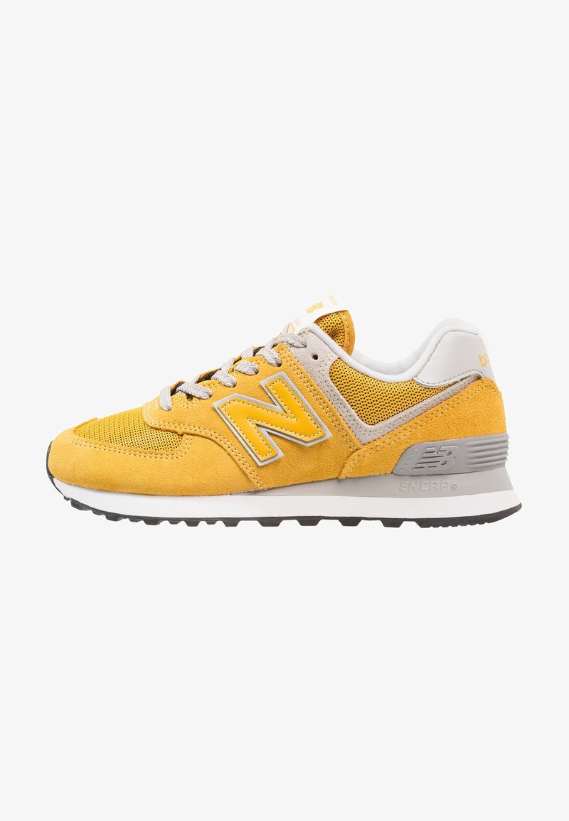 Yellow and gray New Balance sneaker with mesh and suede panels, white sole, gray laces, and "N" logo on the side.