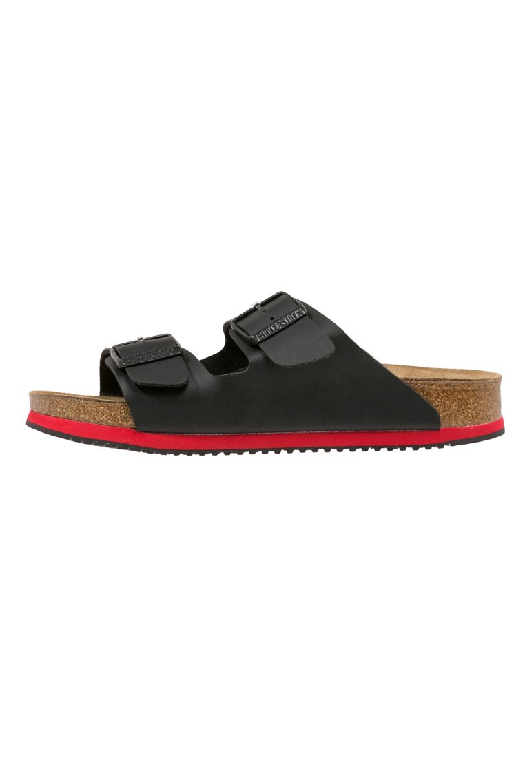 Black slide sandals featuring two adjustable straps, a cork footbed, and a red outsole. Smooth texture with a minimalist design.