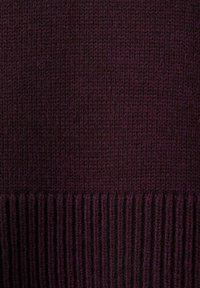 Tessuto a maglia di un viola scuro con orlo a coste nella parte inferiore. Texture liscia con un modello di punto uniforme in tutto il tessuto.