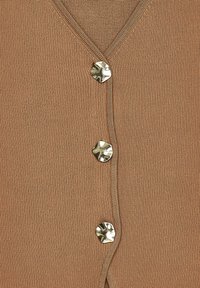 Cardigan lavorato a maglia beige con scollo a V e tre bottoni lucidi in tonalità argento sul fronte. Texture liscia con una leggera lucentezza.